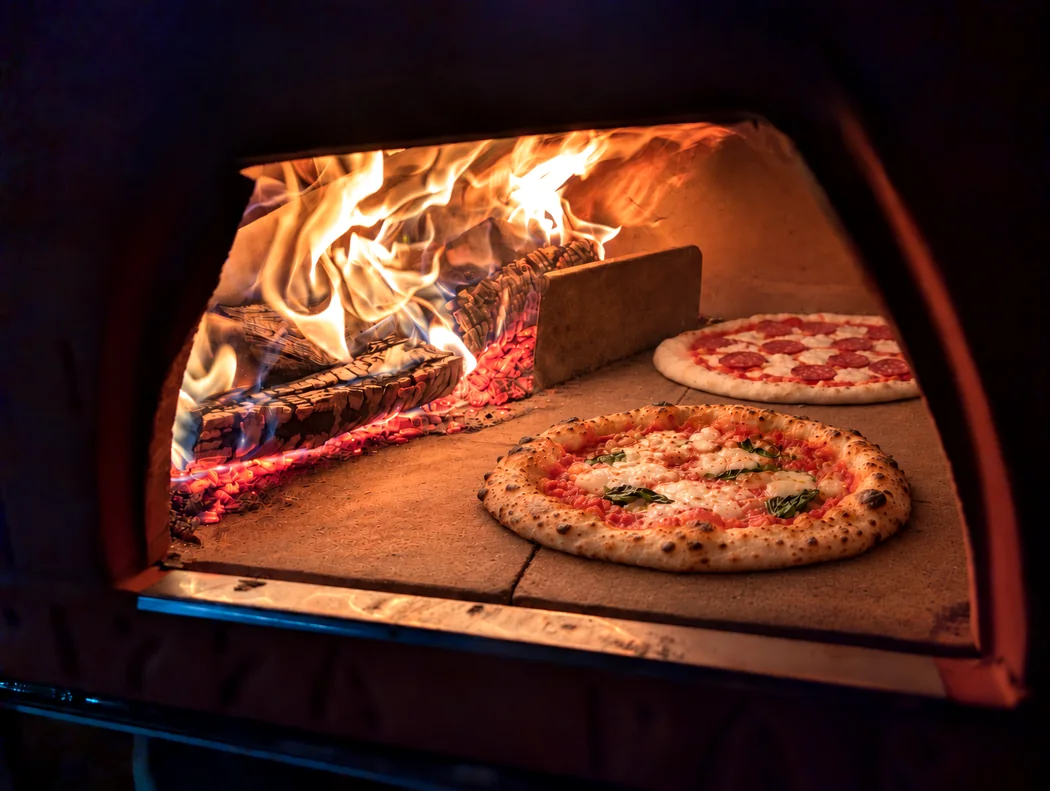 Zwei Pizzen im brennenden Holzofen von ANDOLINI